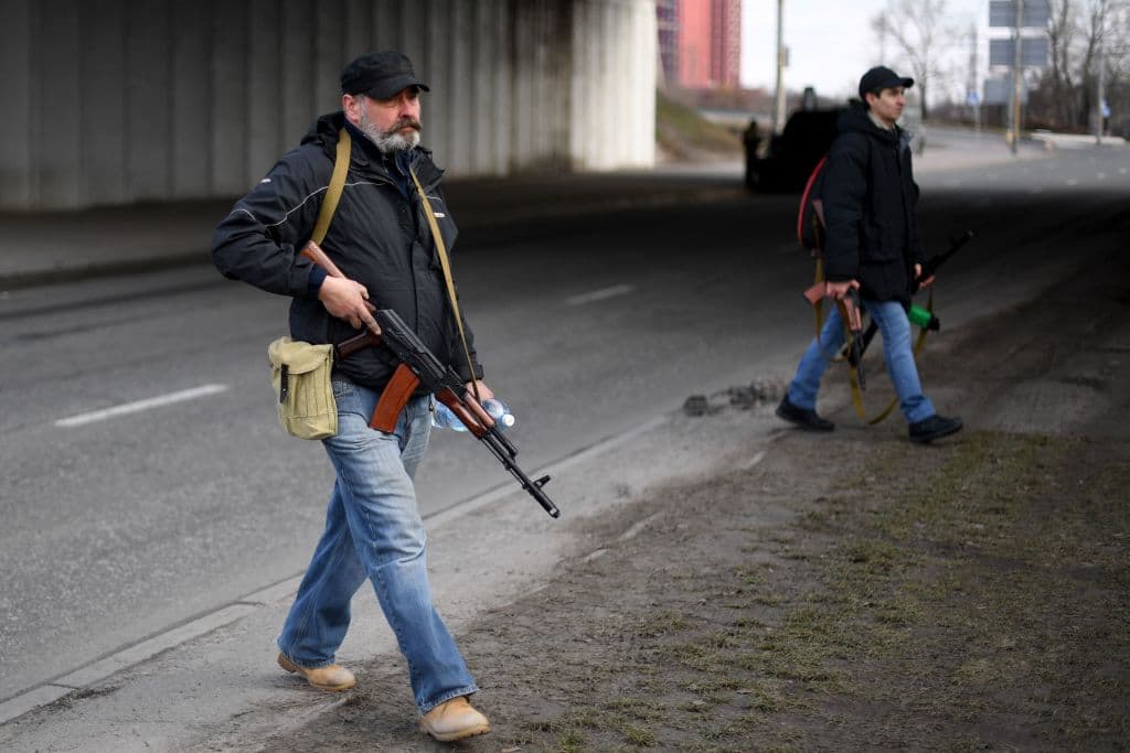 Voluntarios armados protegen una de las vías principales de entrada a la capital este viernes, uno de ellos lleva un fusil AK-47.