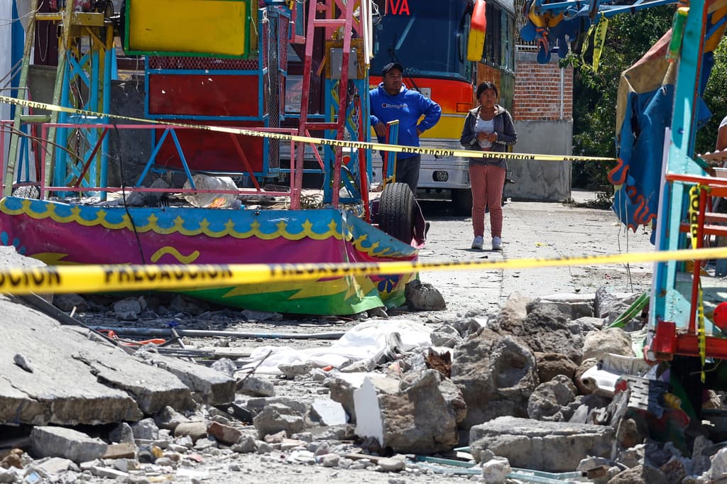 Unos residentes observan la zona destruida por una explosión de fuegos artificiales junto a la iglesia de Santa María Canchesdá en Temascalcingo, México, el domingo 6 de septiembre de 2026. (Foto AP/Ramses Mercado)