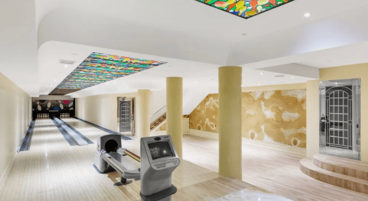 La mansión tiene varias áreas dedicadas al entretenimiento, como una cancha de tenis, otra de squash (bajo techo) y
<b> su propia bolera. </b>