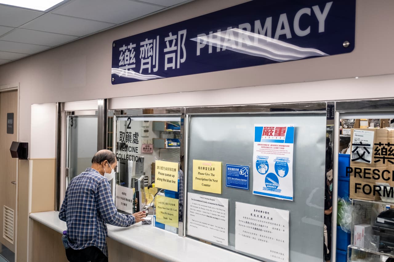 Un hombre recoge medicamentos en una farmacia en Hong Kong. (Photo by Vernon Yuen/NurPhoto via Getty Images)