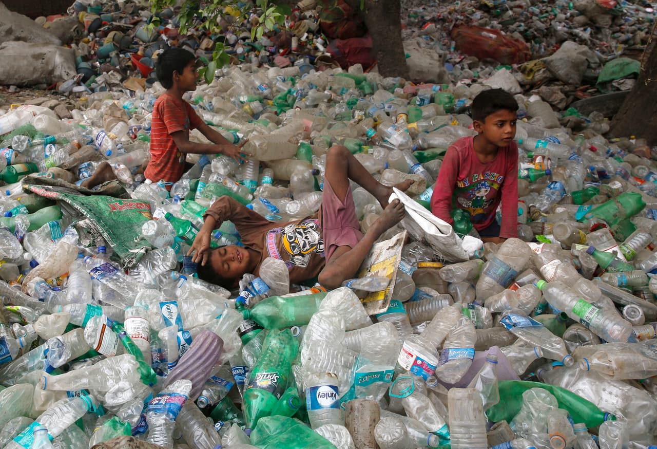 <b>Allahabad, India.</b> Unos niños se relajan sobre botellas de plástico después de juegar durante el Día de la Tierra. 22 de abril de 2017