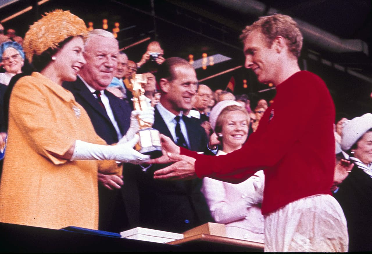 La reina Isabel II entrega la Copa del Mundo, el trofeo Jules Rimet, al capitán de la selección inglesa, Bobby Moore. Inglaterra venció a Alemania en la final en el estadio de Wembley de Londres por 4 goles a 2, tras la prórroga.