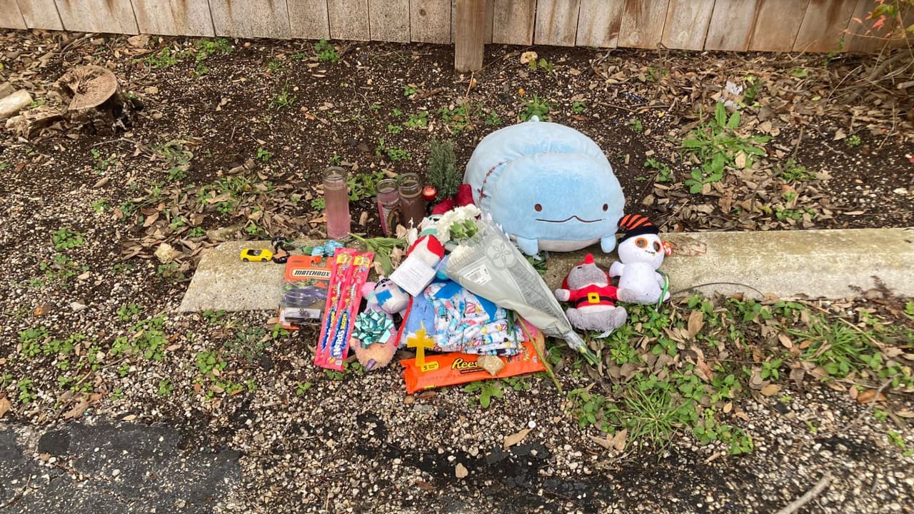 Velas, flores y muñecos de peluche llaman la atención en medio del estacionamiento vacío de la unidad habitacional.