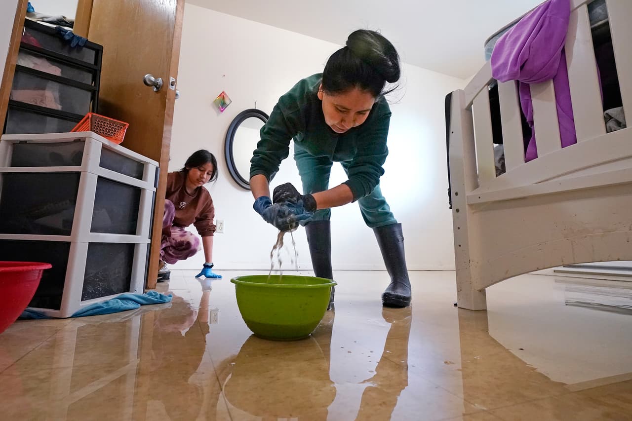 Lucía Cruz Reyes (derecha) y su hija Bedenice limpian su casa inundada en Everson. En esta ciudad se declaró como desaparecido a un hombre después de que su camioneta fuera arrastrada por la inundación. Fue identificado como José García, de 59 años.
<br>