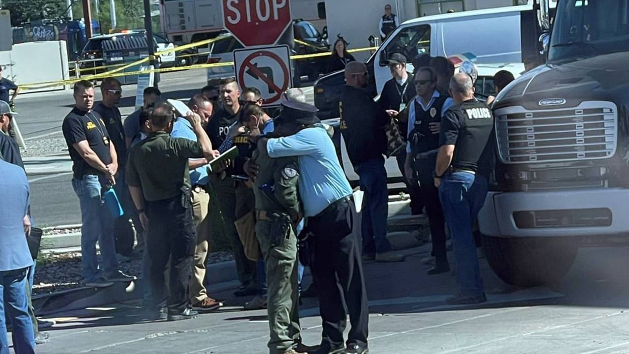 Dos oficiales se abrazan a las afueras de la estación de trenes de Tucson a minutos del tiroteo que dejó un agente de la DEA muerto y dos heridos.