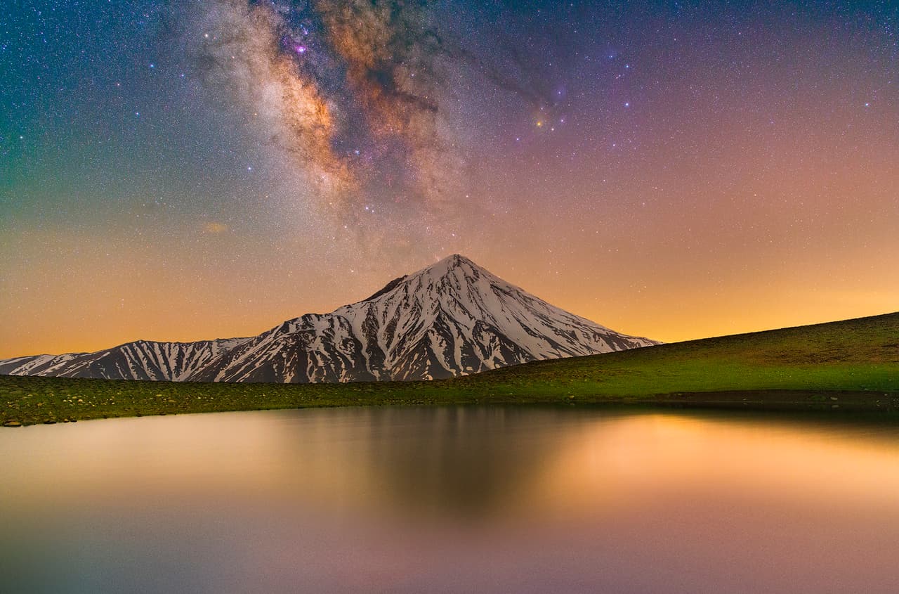 <b>‘Damavand y la Vía Láctea’</b>
<br>
<br>Esta imagen muestra el esplendor del monte Damavand, al norte de Teherán, una de las maravillas naturales de Irán. La Vía Láctea brilla a la izquierda del cielo y se puede ver la contaminación lumínica de Teherán a la derecha. El fotógrafo tuvo que caminar durante siete horas y ascender más de 1,000 metros para llegar al punto donde realizó las tomas. La imagen final es la combinación de 10 fotografías diferentes.
<br>