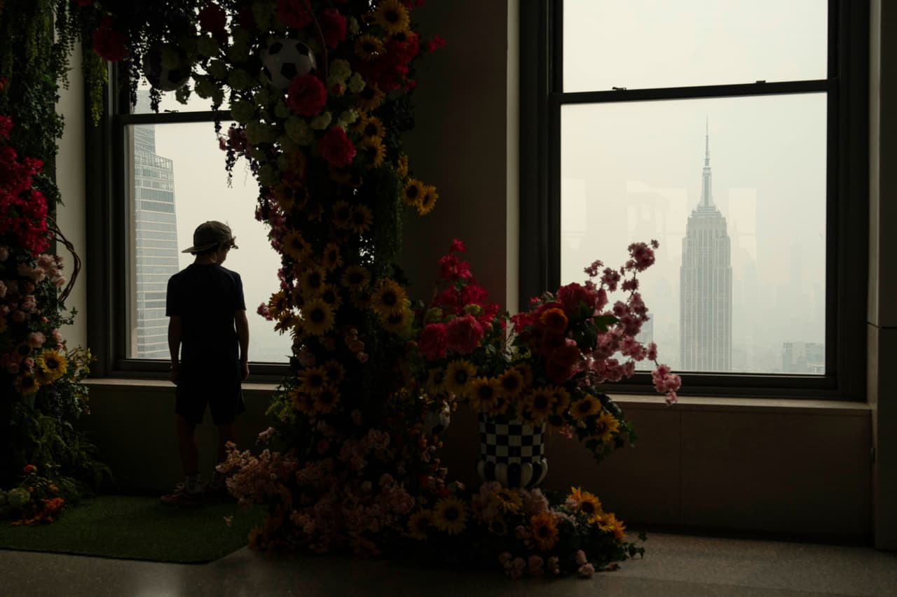 Una persona mira por una ventana en la plataforma de observación Top of the Rock mientras el humo de los incendios forestales se cierne sobre Nueva York, el jueves 16 de julio de 2026. Para resguardar los interiores de la bruma, los expertos dicen que se deben revisar los sellos de ventanas y puertas, invertir en un buen sistema de ventilación y revisar los filtros de aire.