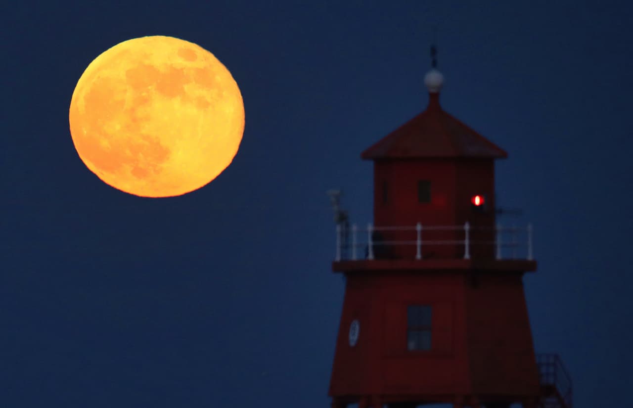La Superluna de mayo de 2020 se levanta sobre el faro de Groyne en South Shields, en la costa noreste, el jueves 7 de mayo de 2020. ¿Por qué el nombre?
<b>Cada mes del año tiene Luna llena, cuando se cumple el ciclo lunar de casi 28 días. Cada luna tiene un nombre. </b>