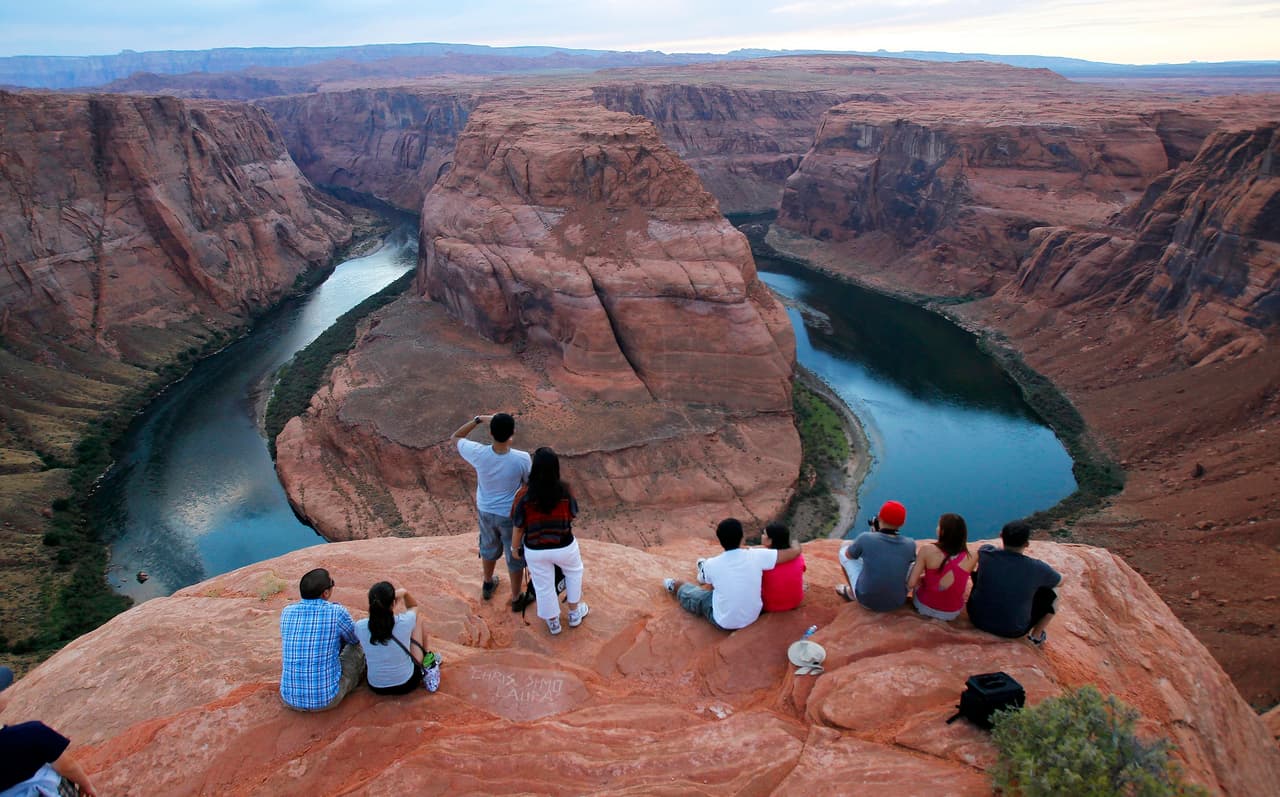 Un grupo de personas mira el río Colorado en el parque nacional Glen Canyon, en Arizona.