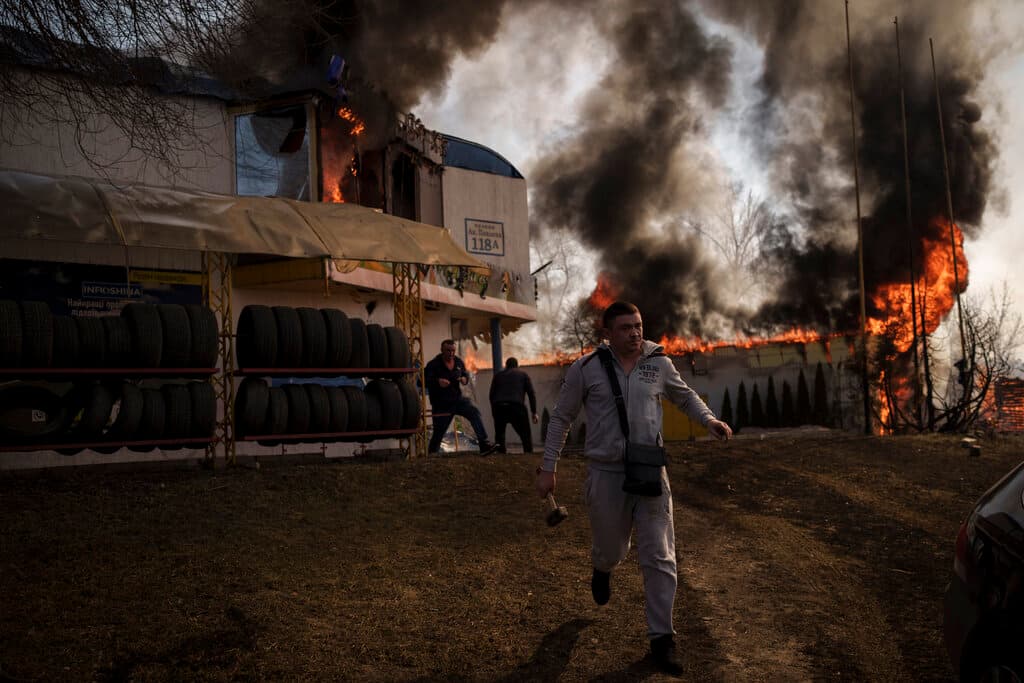 Ucranianos tratan de rescatar insumos de una tienda en llamas tras un bombardeo en Járkov, Ucrania. Casi 5,000 personas han fallecido en Ucrania desde el inicio de la invasión rusa. Casi la mitad de esas víctimas se encontraban en Mariupol, una ciudad sitiada por las fuerzas rusas.
