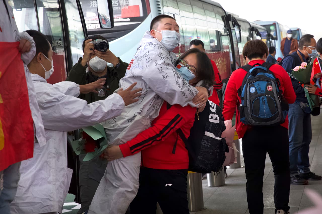 Un grupo de médicos celebra que ya pueden regresar a sus casa en otras provincias de China en el aeropuerto de Wuhan. Tras 11 semanas de confinamiento, la gente salió a la calle y miles subieron a los primeros trenes y aviones que partieron de la ciudad dónde se originó la pandemia del coronavirus.