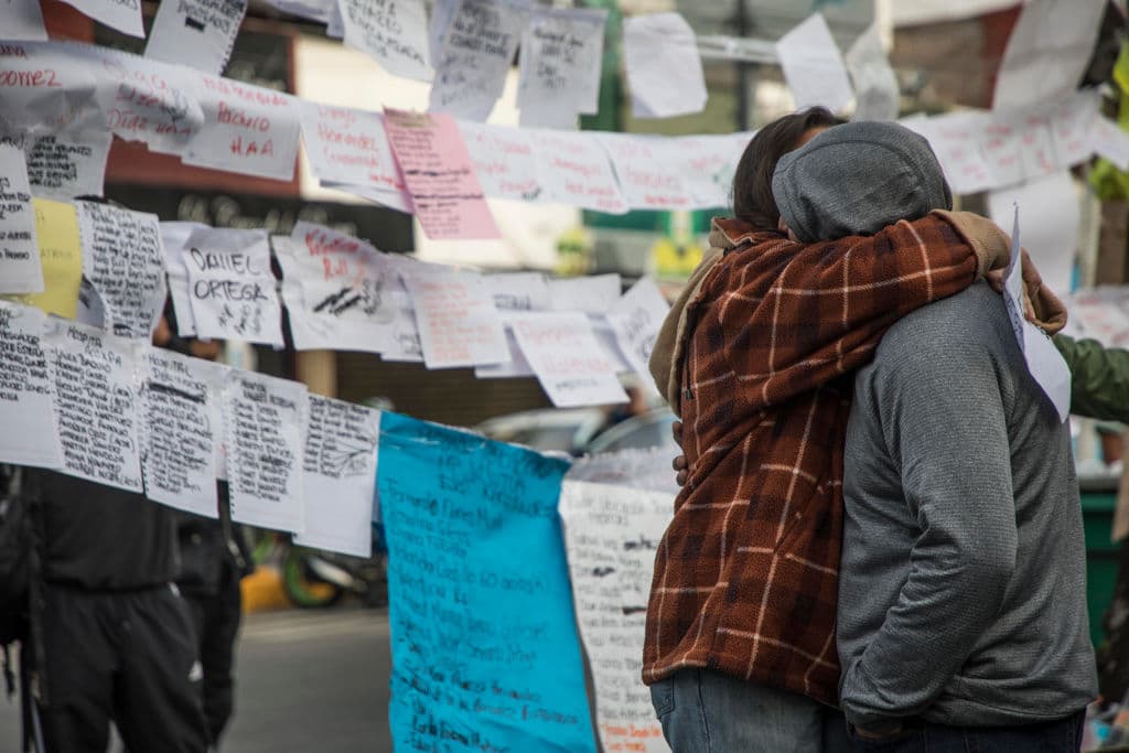 Familiares de víctimas de la escuela Enrique Rébsamen a un día del terremoto de magnitud 7.1. Al fondo, nombres de desaparecidos.