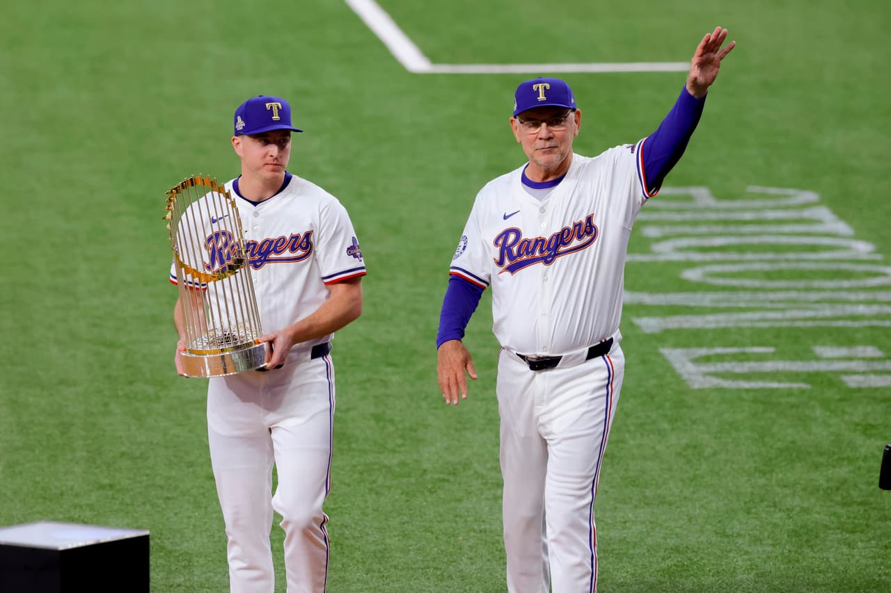 Josh Sborz y Bruce Bochy dieron la bienvenida a los aficionados cargando
<b>el trofeo de la Serie Mundial de Béisbol</b>, que los Texas Rangers ganaron en 2023.