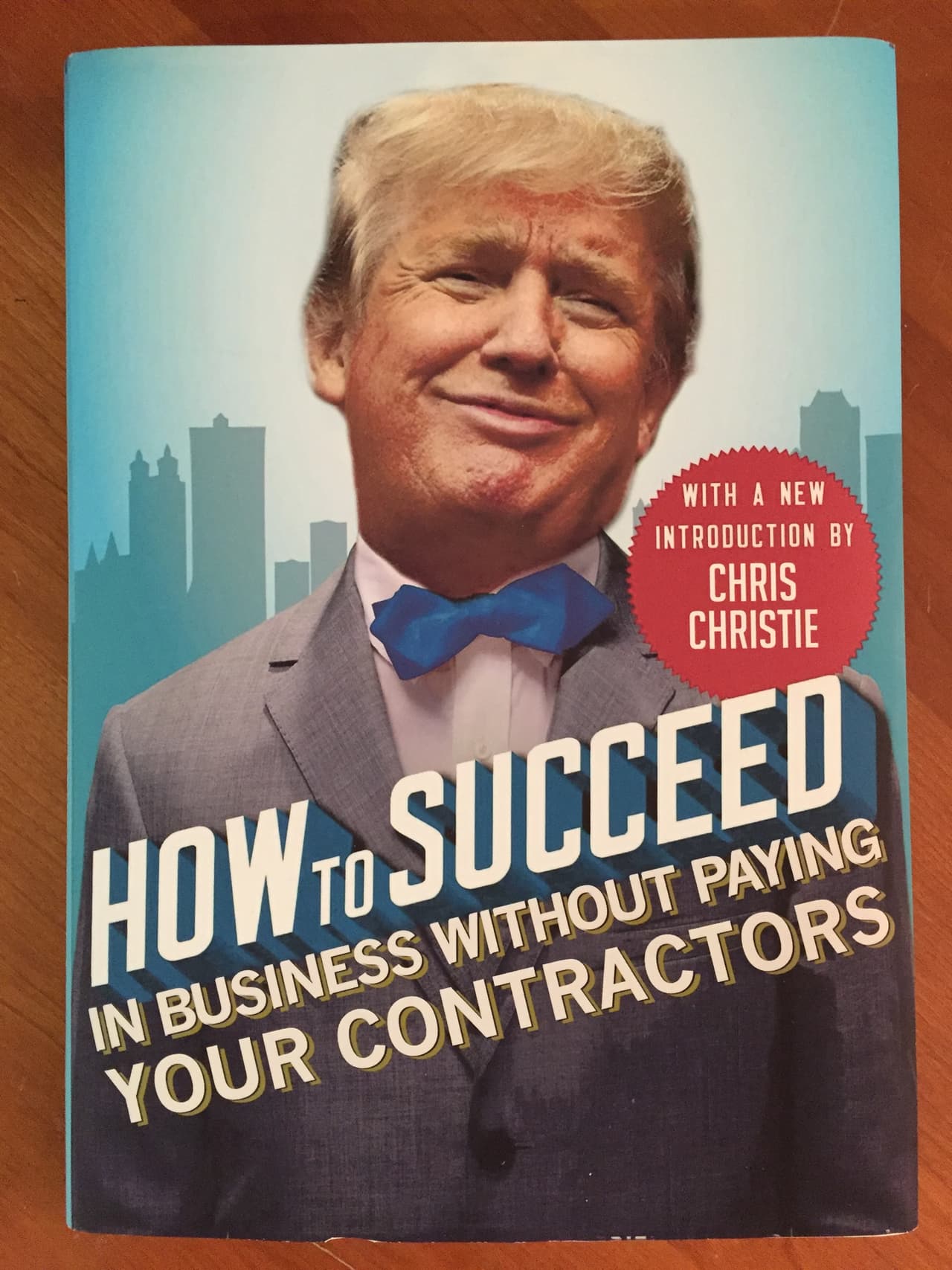 <b>'Cómo triunfar en los negocios sin pagar a tus contratistas', </b>el título de este libro apela a esa constante actitud de Trump, develada por varios medios, de no pagar o pagarle a medias las deudas a los contratistas con los que trabaja. Con gracia en el circulito rojo en donde siempre se anuncia el prólogo se dice:
<b>"Con una nueva introducción de Chris Christie",</b> el polémico gobernador de Nueva Jersey empantanado por el caso del "Bridgegate".