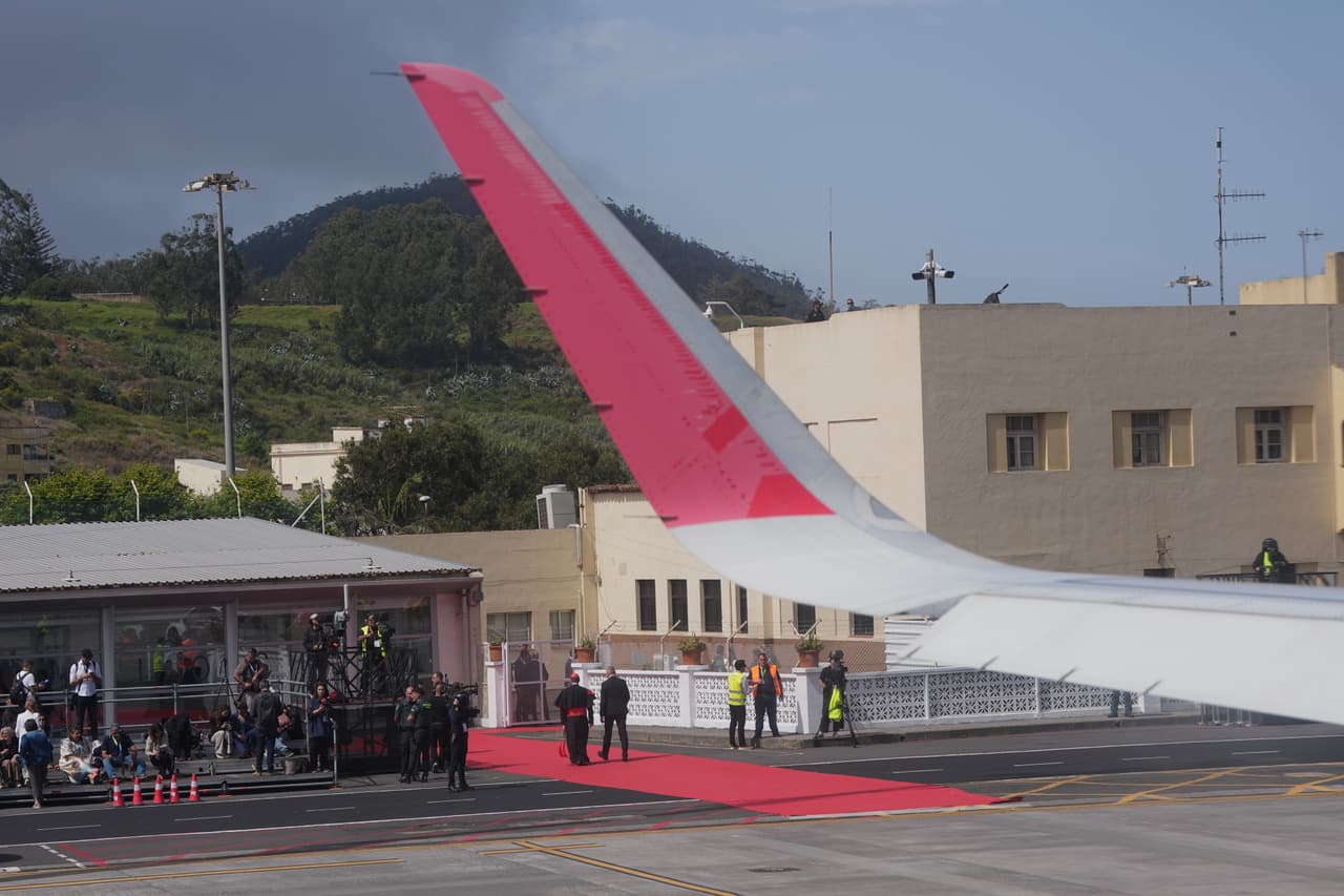 Un grupo de periodistas se encuentra junto al avión papal tras retrasarse el despegue en el Aeropuerto Internacional de Los Rodeos, en las Islas Canarias (España), el viernes 12 de junio de 2026. (Foto AP/Alessandra Tarantino)