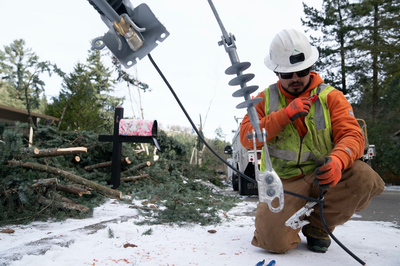 Un trabajador de la empresa eléctrica de Oregon trabaja restableciendo el tendido afectado por la tormenta helada.