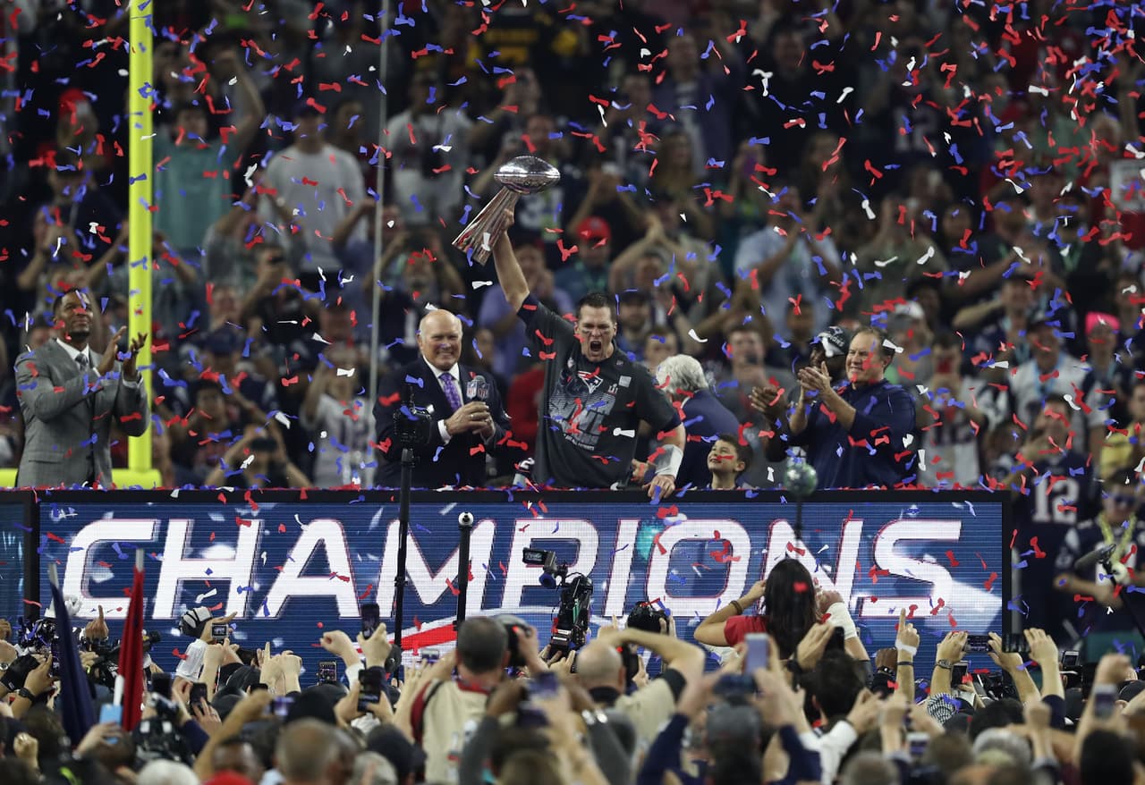 HOUSTON, TX - FEBRUARY 05: Tom Brady #12 of the New England Patriots raises the Vince Lombardi trophy after the Patriots defeat the Atlanta Falcons 34-28 in overtime of Super Bowl 51 at NRG Stadium on February 5, 2017 in Houston, Texas. (Photo by Elsa/Getty Images)