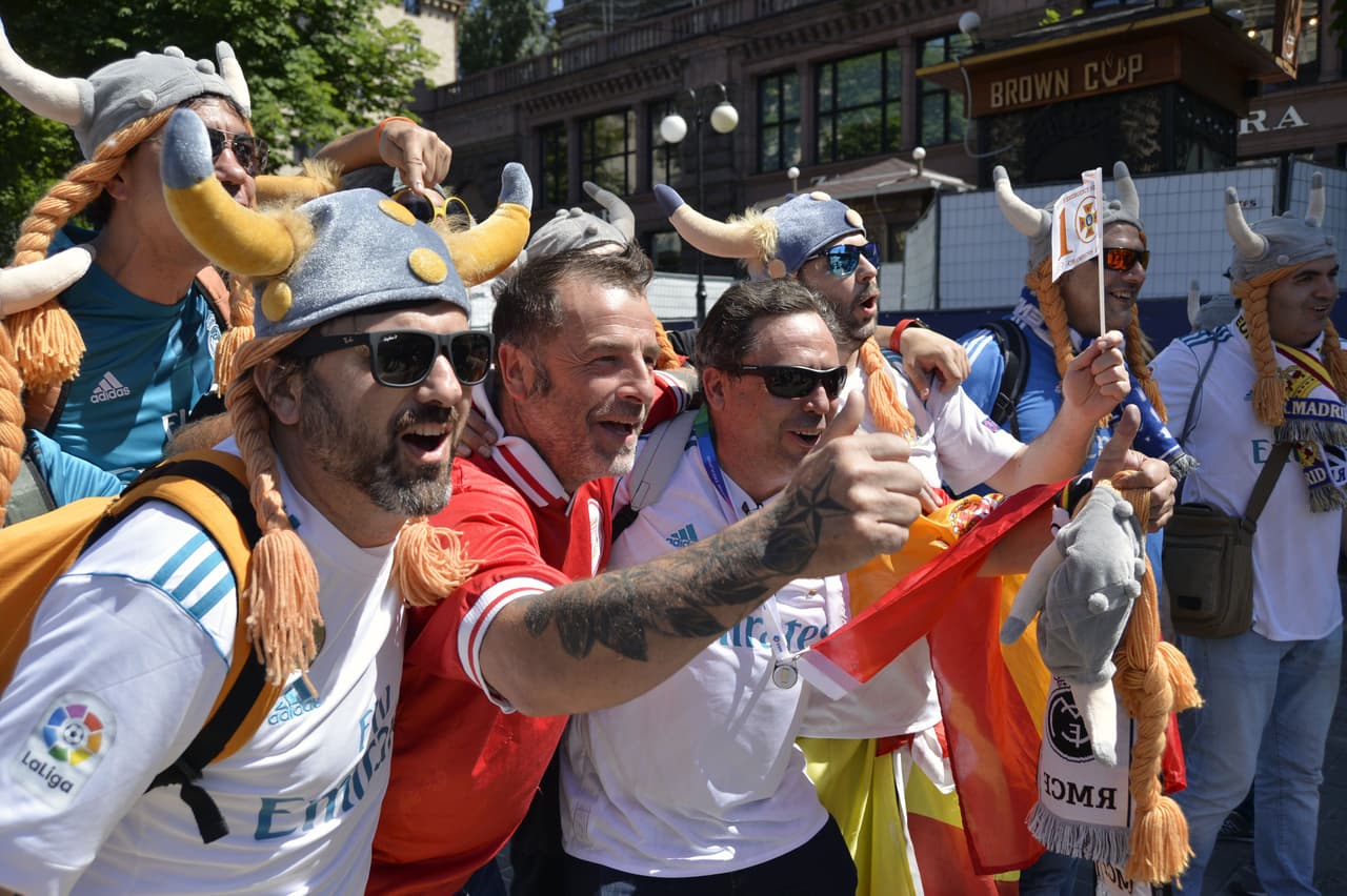 Liverpool FC and the Real Madrid fans react as they pose for the picture at the fan zone in central Kiev on May 26, 2018 ahead of 2018 UEFA Champions League final football match between Real Madrid and Liverpool FC. - the International Committee of the Red Cross (ICRC) is partnering with the European Football Association (UEFA) to raise awareness of the risks to life and safety still faced by civilians in Eastern Ukraine, where an armed conflict continues into its fifth year. (Photo by Sergei CHUZAVKOV / AFP) (Photo credit should read SERGEI CHUZAVKOV/AFP/Getty Images)