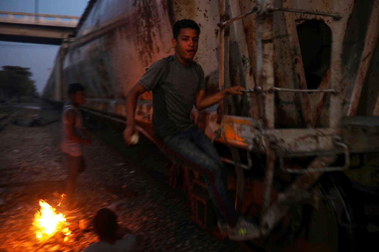 En esta foto del 21 de noviembre de 2019, un migrante centroamericano se agarra de las escaleras de un tren que espera lo lleve al norte, en Coatzacoalcos, en el estado mexicano de Veracruz. (AP Foto/Félix Márquez)