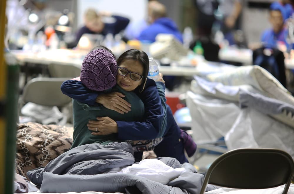 El coliseo Juan Aubín Cruz Abreu de Manatí se convirtió en el Refugio Médico de Puerto Rico. Se estableció el 3 de octubre y ese día atendió solamente 2 pacientes. Ahora atiende un promedio de 200 diarios. En la fotografía, una voluntaria abraza a un paciente del refugio hospital.