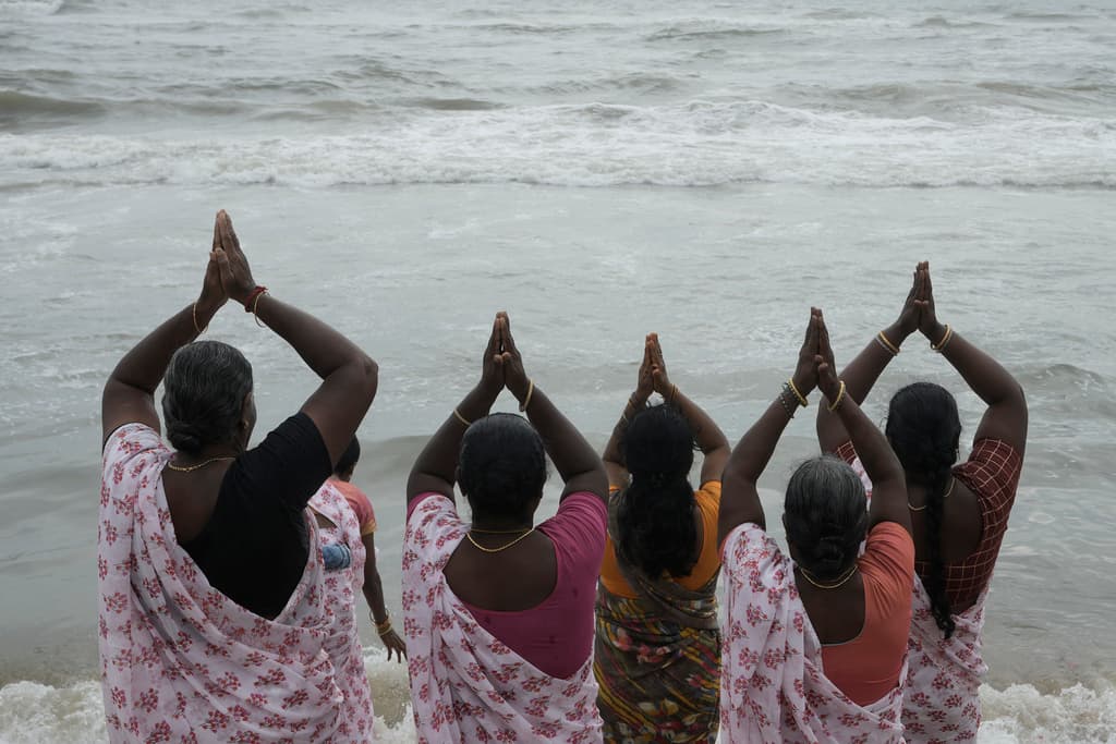 Un grupo de mujeres ofrecen homenajes en recuerdo de las víctimas del tsunami de 2004 en el 20º aniversario de la tragedia, en Marina Beach en Chennai, India.