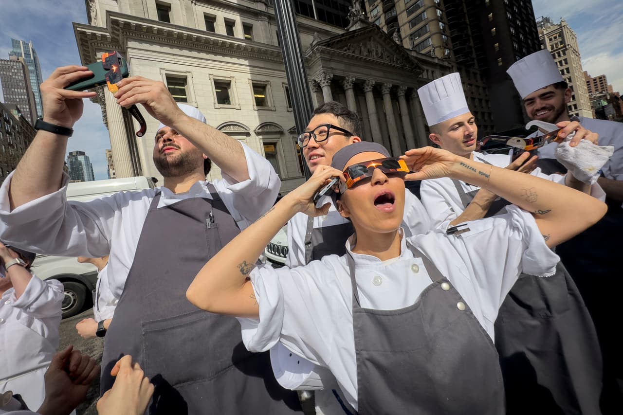 Trabajadores de un restaurante en Manhattan toman un descanso para salir a ver
<a href="https://www.univision.com/noticias/asi-se-vio-desde-el-espacio-como-el-eclipse-oscurecio-parte-de-la-tierra-video">el eclipse solar total del 8 de abril de este año.</a> Ciudades como San Antonio y Dallas, en Texas, pudieron disfrutar de la penumbra completa del fenómeno, mientras que zonas desde Mazatlán, México, hasta el norte de ese país también lo apreciaron.