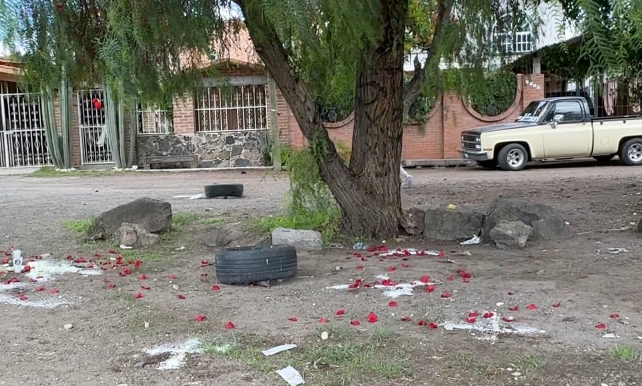 Pétalos de rosa y cruces trazadas sobre la tierra permanecen en el lugar del ataque armado en Guanajuato, México, como homenaje a las víctimas.