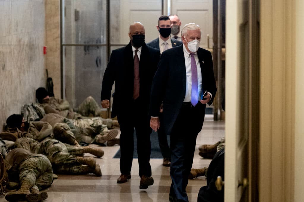 El jefe de la bancada demócrata en la Cámara de Representantes Steny Hoyer llega al Capitolio el 13 de enero del 2021, mientras efectivos de la Guardia Nacinoal reposan en el piso.
