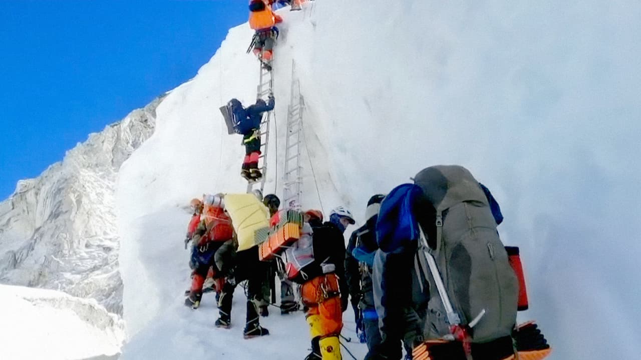 Los montañistas deben esperar su turno para acceder a una pequeña escalera en uno de los puntos de mayor tráfico hacia la cumbre del Monte Everest, la mayor cima del mundo. La reticencia de Nepal a limitar el número de permisos para subir la icónica montaña provocó una peligrosa aglomeración y contribuyó a un elevado número de decesos, dijeron experimentados montañistas a la agencia AP.