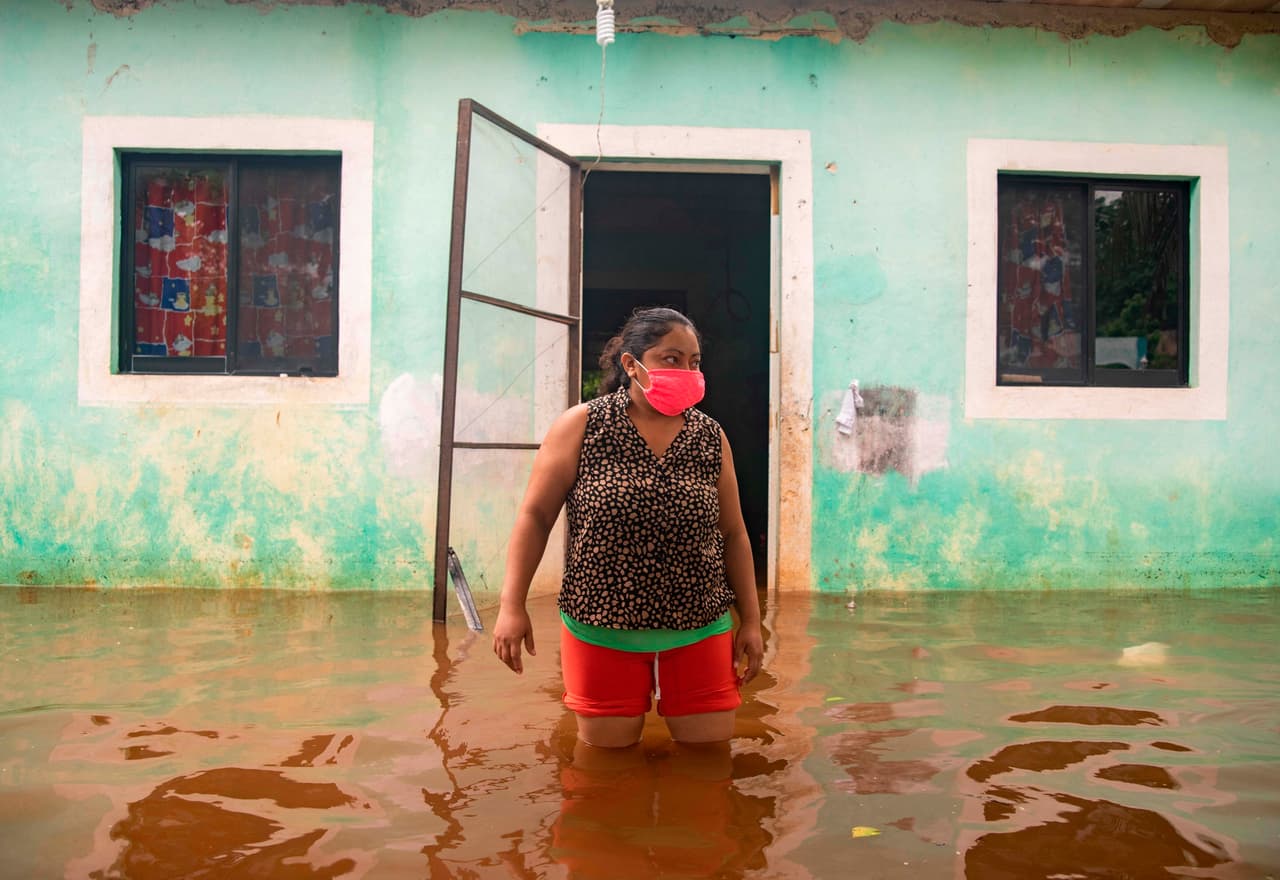 Una mujer sale de su vivienda inundada en Tecoh, en el estado de Yucatán. Las autoridades mexicanas informaron este miércoles que mantienen la vigilancia en el litoral del Golfo de México por efectos de la tormenta tropical Cristóbal, que continúa sobre tierra con pronosticó que volverá al mar en los próximos días.
<br>