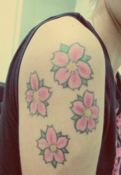 Tatuajes de flores, pluma y frase enviados por Claudia