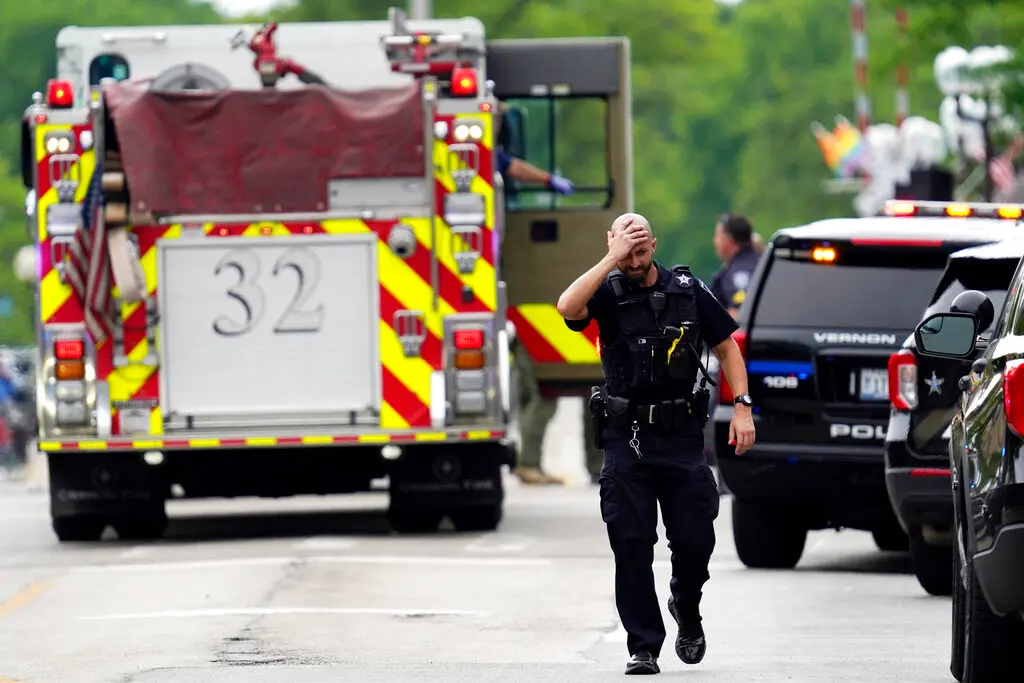 A police officer reacts as he walks in downtown Highland Park, Ill., a suburb of Chicago, Monday, July 4, 2022, where a mass shooting took place at a Highland Park Fourth of July parade. (AP Photo/Nam Y. Huh)