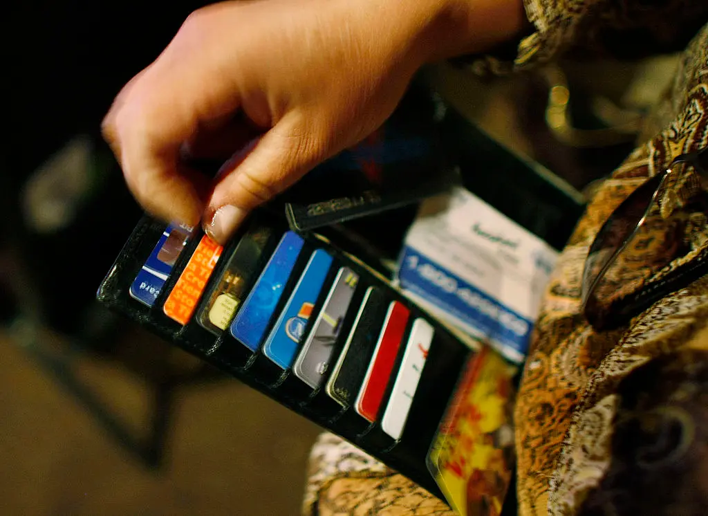 KENDALL, FL - MARCH 07: Ileana Garcia looks in her wallet for credit cards she wants to melt over a hot plate as she tries to dig herself out of credit card debt during a sermon by Kevin Cross about faith-based financial management at the Miami Vineyard Community Church on March 7, 2009 in Kendall, Florida. Cross preaches to people about the biblical principles of money management with his idea of steps that should be taken for handling finances to glorify and honor God. With the economic hard times that have fallen upon many people, churches around the country are trying new programs such as Cross's Margin and Meaning events, to guide people out of their debt and get back on their feet financially. (Photo by Joe Raedle/Getty Images)