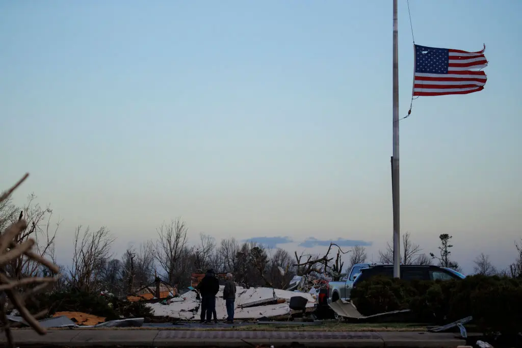 MAYFIELD, KY - DECEMBER 11: People survey tornado damage of the downtown area on December 11, 2021 in Mayfield, Kentucky. Multiple tornadoes tore through parts of the lower Midwest late on Friday night leaving a large path of destruction and unknown fatalities. (Photo by Brett Carlsen/Getty Images)